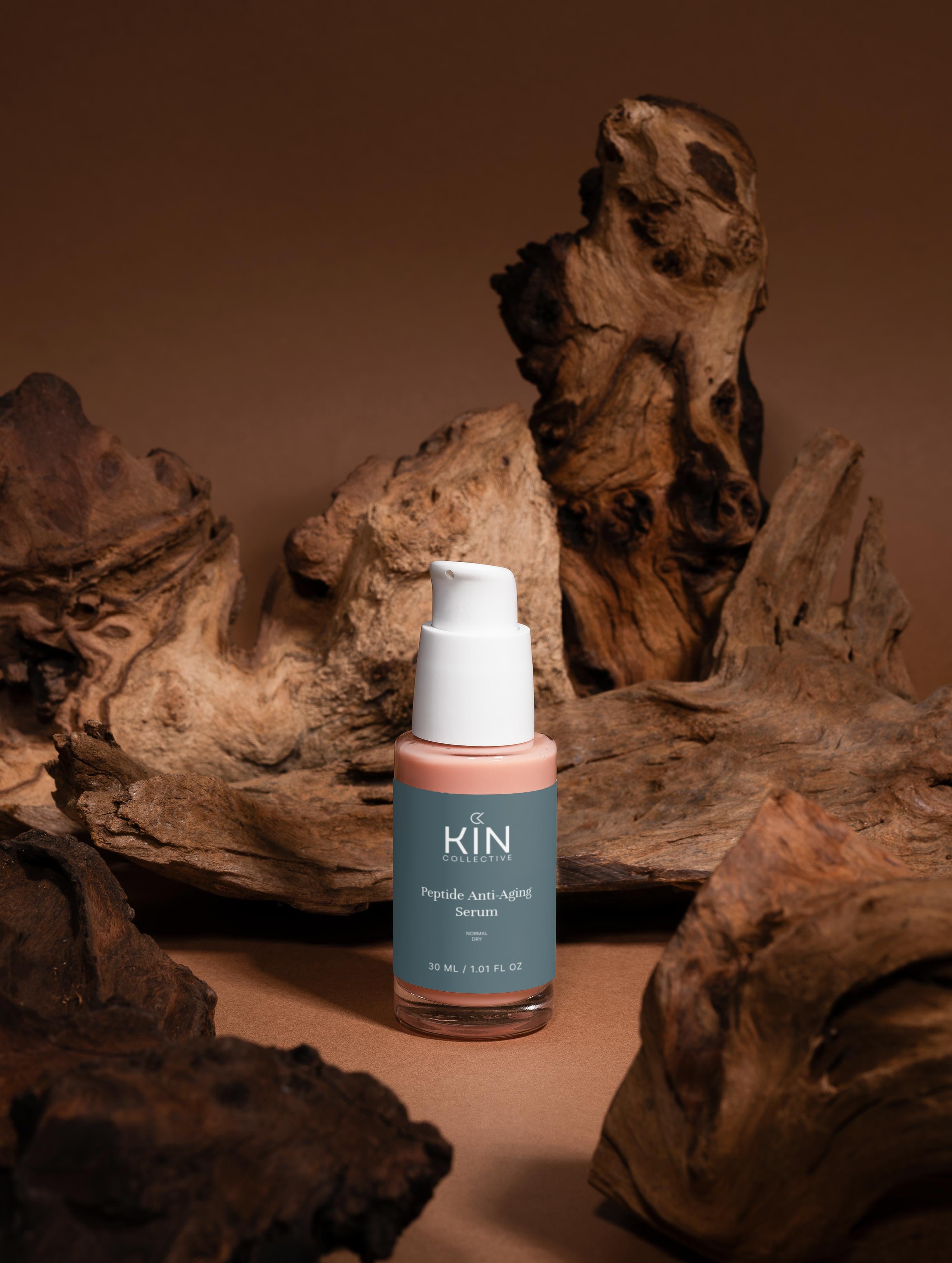 Peptide anti-aging serum bottle with pump surrounded by natural wood on a brown background