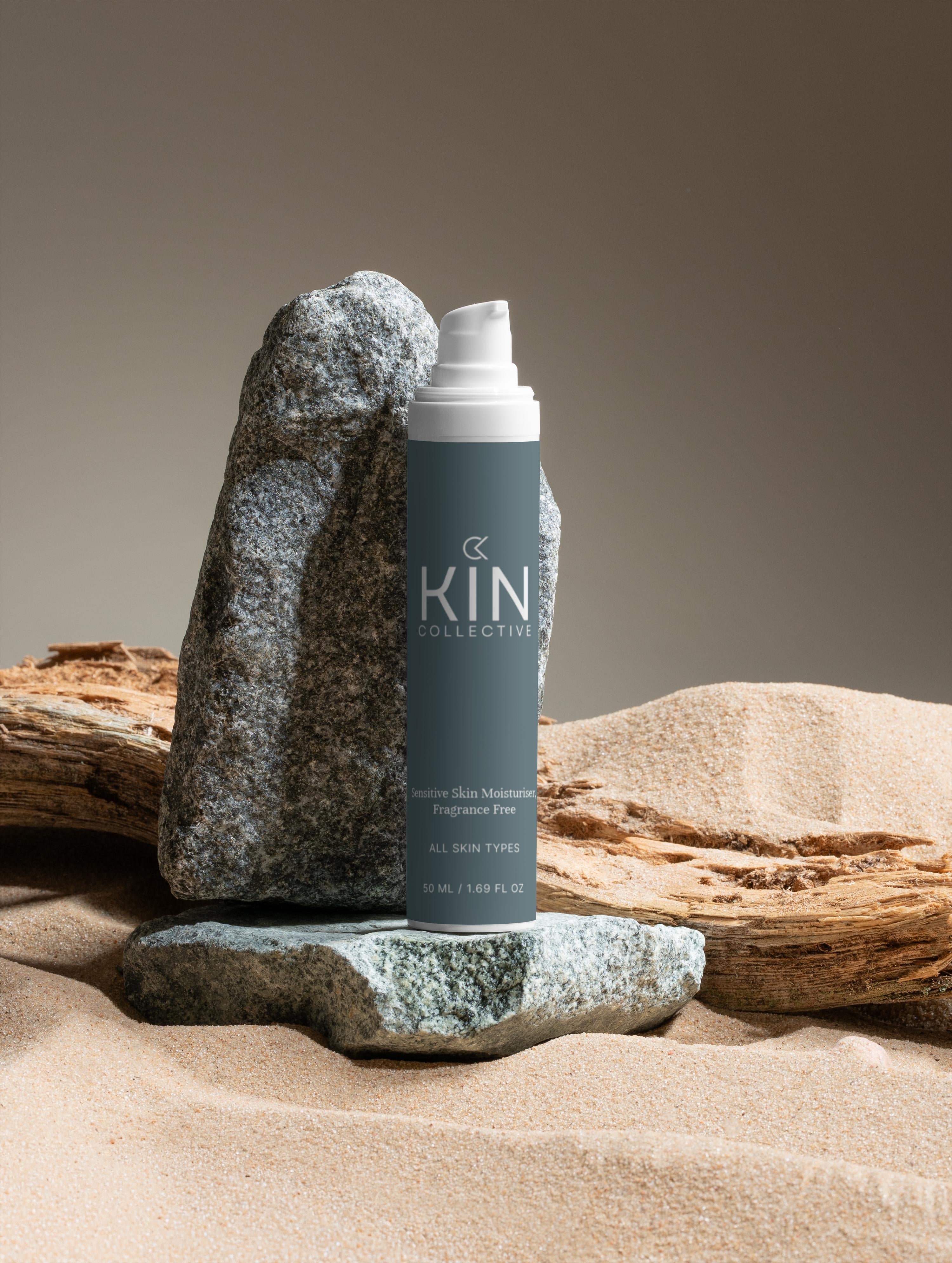 Fragrance free sensitive skin moisturizer bottle on sand with rocks and driftwood