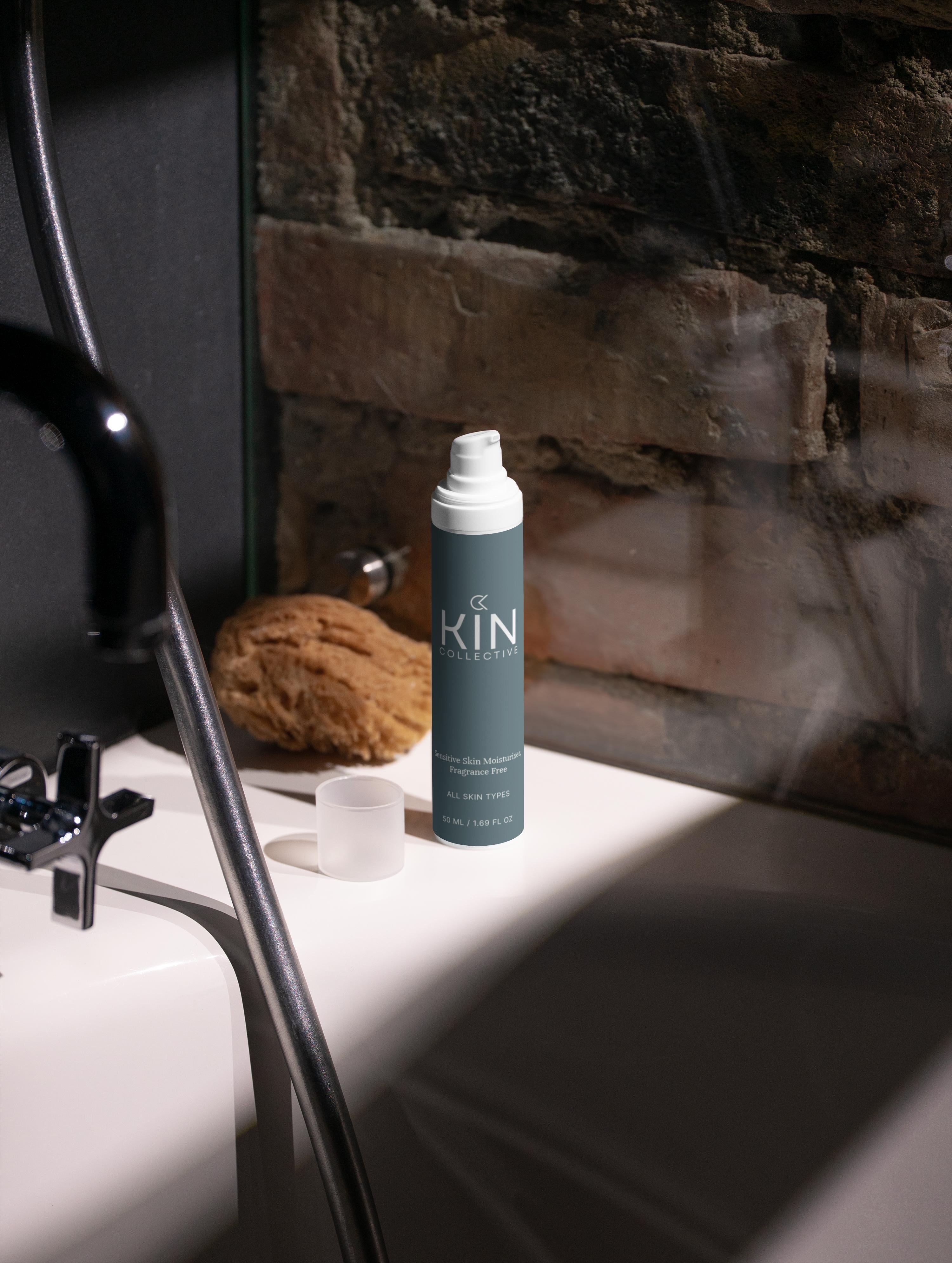 Sensitive skin moisturizer bottle on bathtub ledge with sponge and exposed brick wall