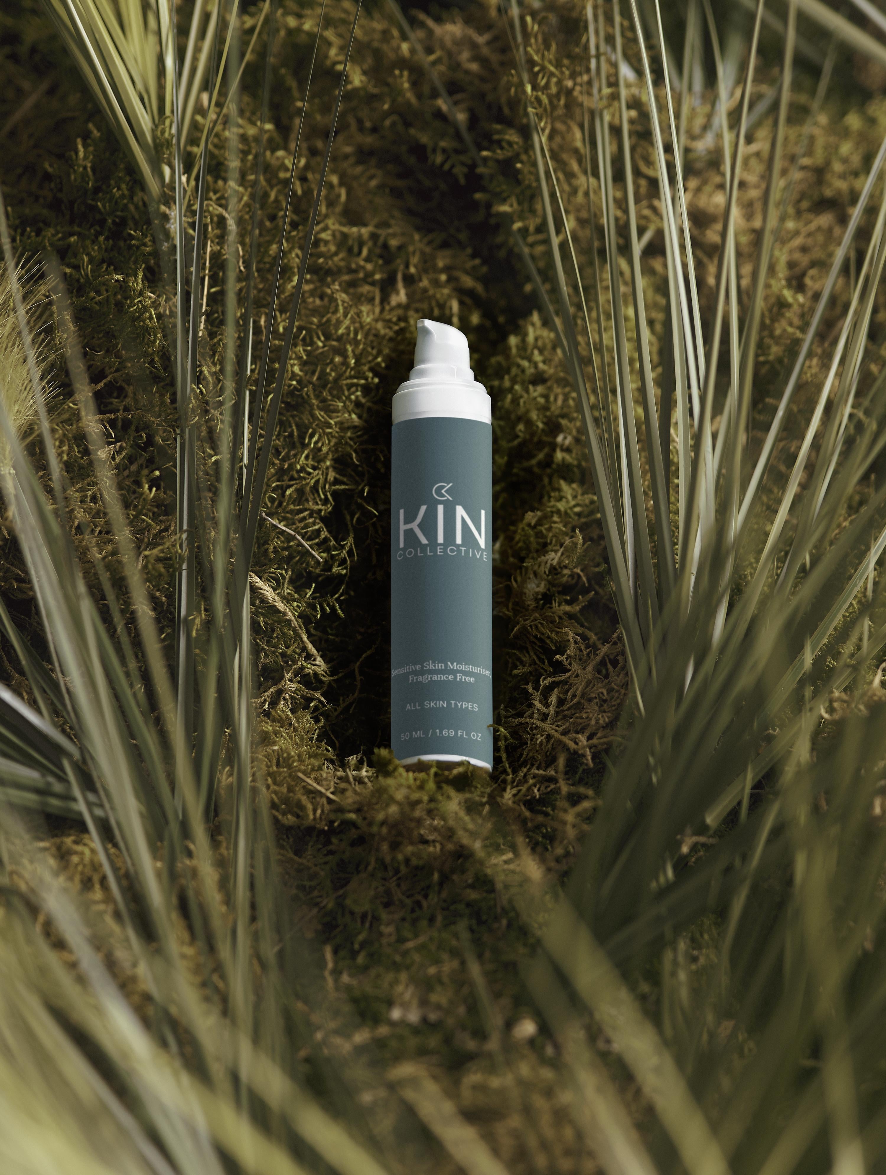 Sensitive skin moisturizer bottle on green moss with natural foliage background