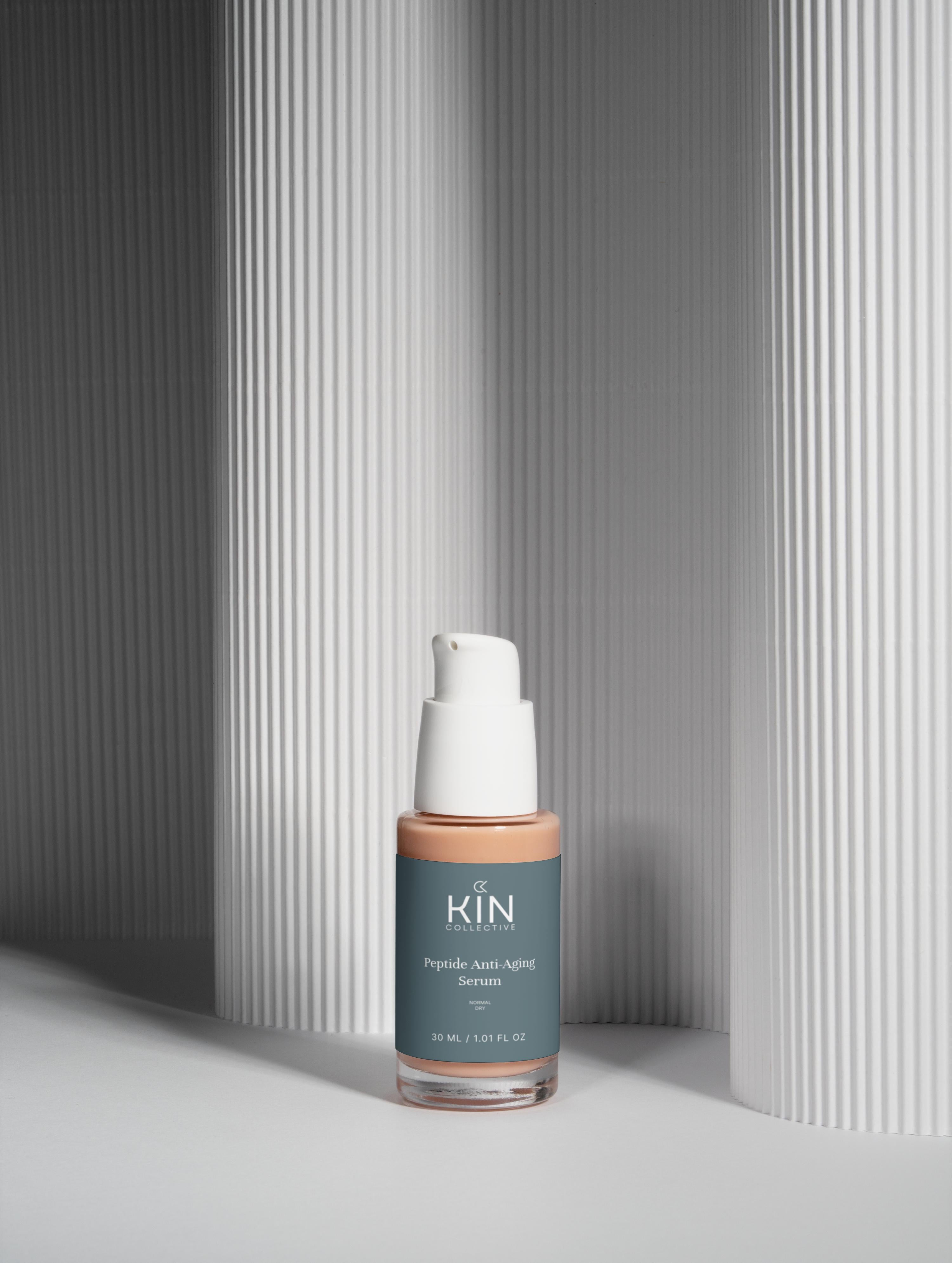 Peptide anti-aging serum bottle for sensitive skin on a minimalist white background
